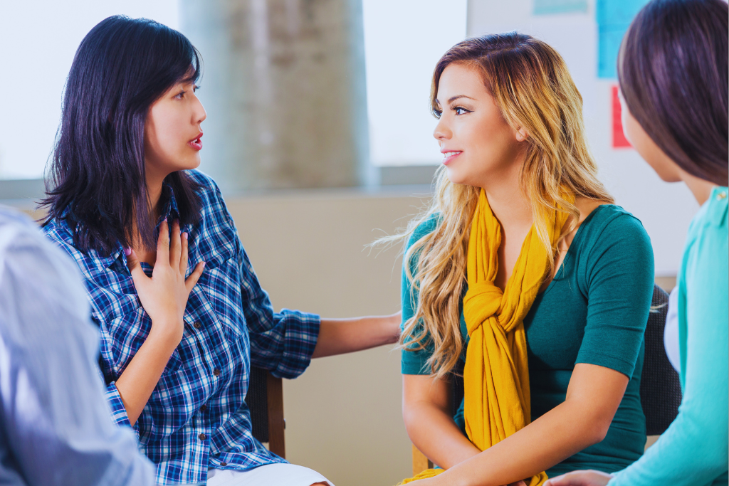 A woman opening up during a one-on-one conversation in a group rehab setting, showcasing the personalized support offered by Shively Kentucky Drug and Alcohol Rehab Resources.
