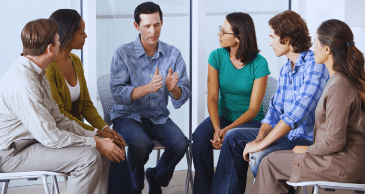 A group therapy session where a man shares his experiences with others attentively listening, symbolizing the importance of support systems in recovery. This highlights the Danville Kentucky Drug and Alcohol Rehab Resources designed to help individuals overcome addiction.