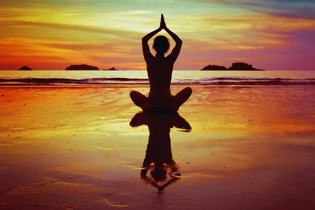 A person meditating on the beach during sunset, symbolizing holistic healing and wellness available through St. Matthews Kentucky Drug and Alcohol Rehab Resources.