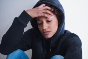 woman showing signs of opiate addiction by withdrawing from friends and family