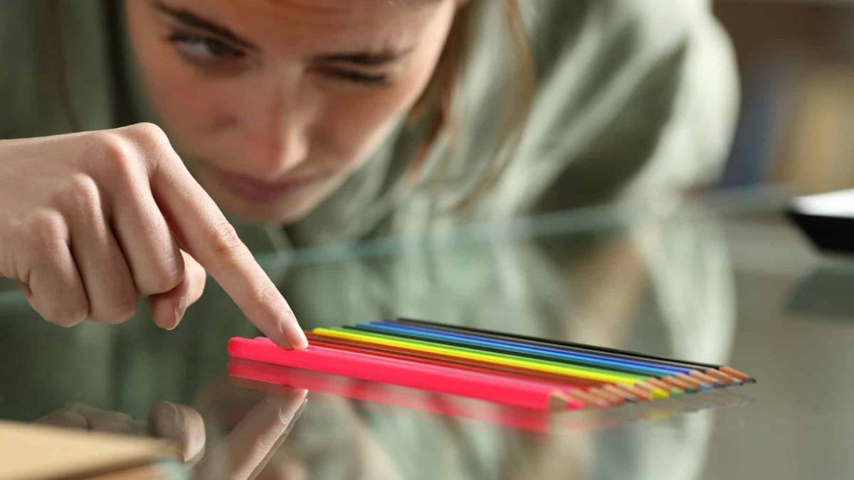 Woman organizes colored pencils in an obsessive manner. Louisville OCD clinic can help manage this behavior.