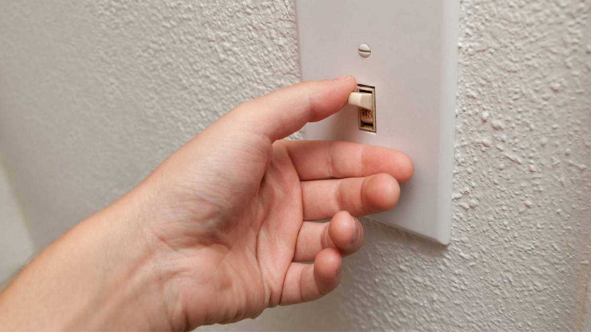 A person obsessively checking the light switch, flipping it on and off. 