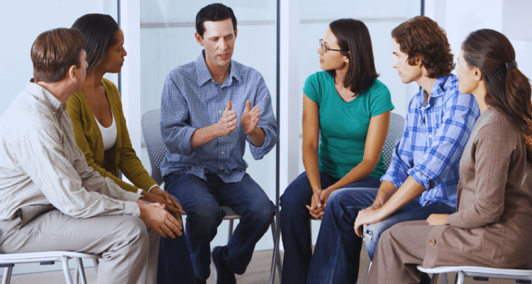 A group therapy session where a man shares his experiences with others attentively listening, symbolizing the importance of support systems in recovery. This highlights the Danville Kentucky Drug and Alcohol Rehab Resources designed to help individuals overcome addiction.